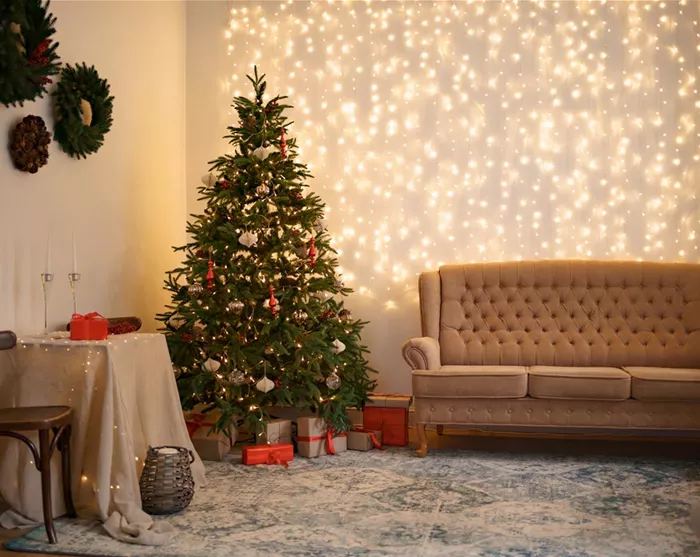 festliches-interieur-mit-bequemem-sofa-und-geschmuecktem-weihnachtsbaum.jpg