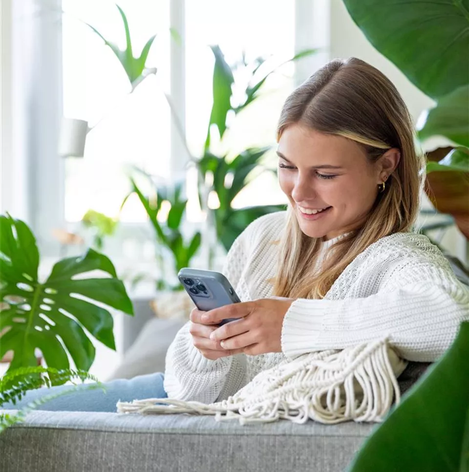 Jungle Ambiente - Frau mit Handy auf dem Sofa